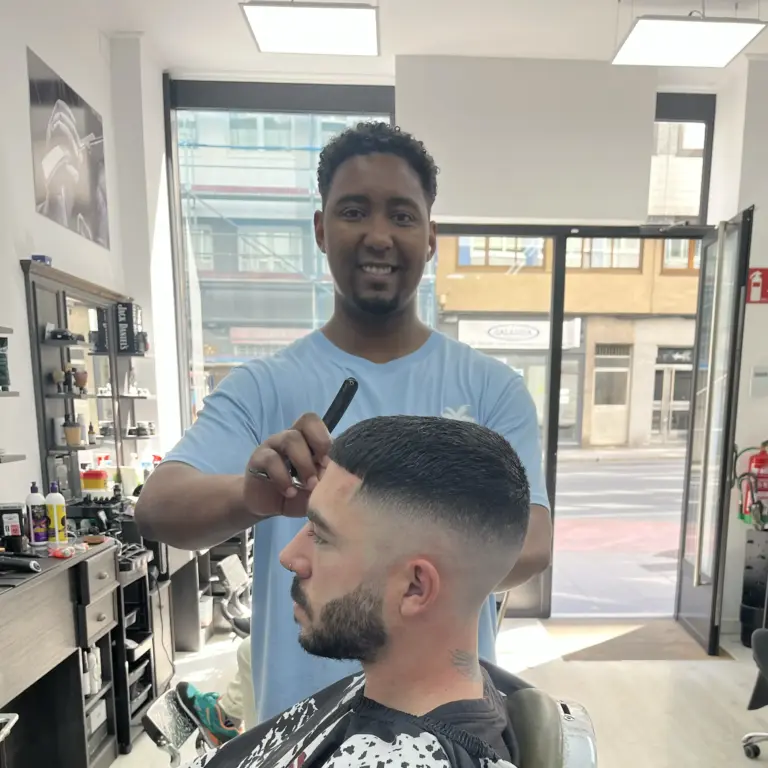 Barbero realizando un corte skin fade masculino en una barbería de A Coruña